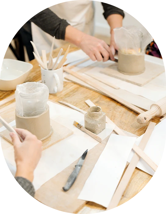 Participants à un atelier créatif travaillant sur des objets en argile – ambiance conviviale et manuelle
